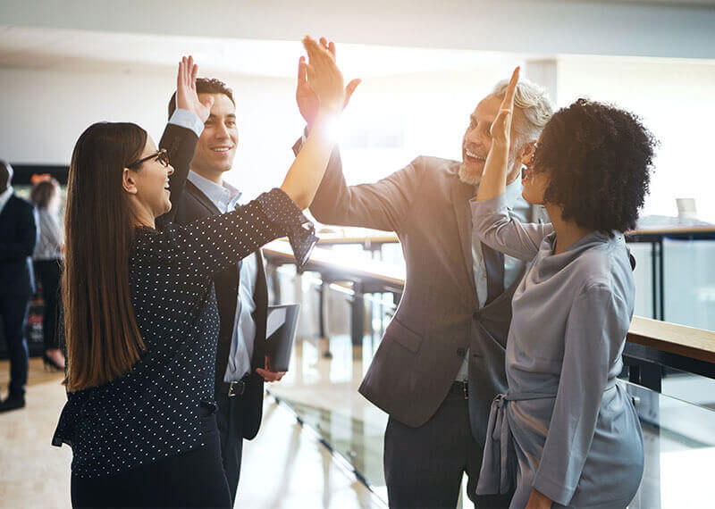 A group of four people giving each other high fives