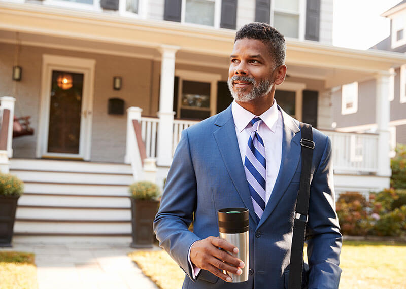A man with coffee leaving the house