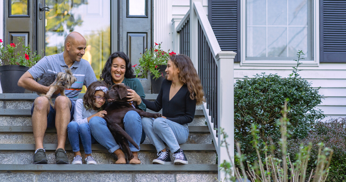 family-with-dogs-sitting-on-porch-of-house