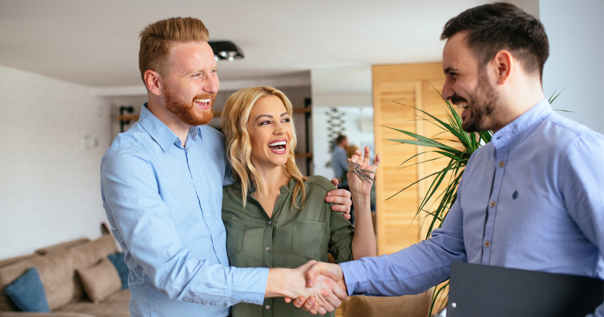 financial adviser congratulating to a young couple for buying a new house