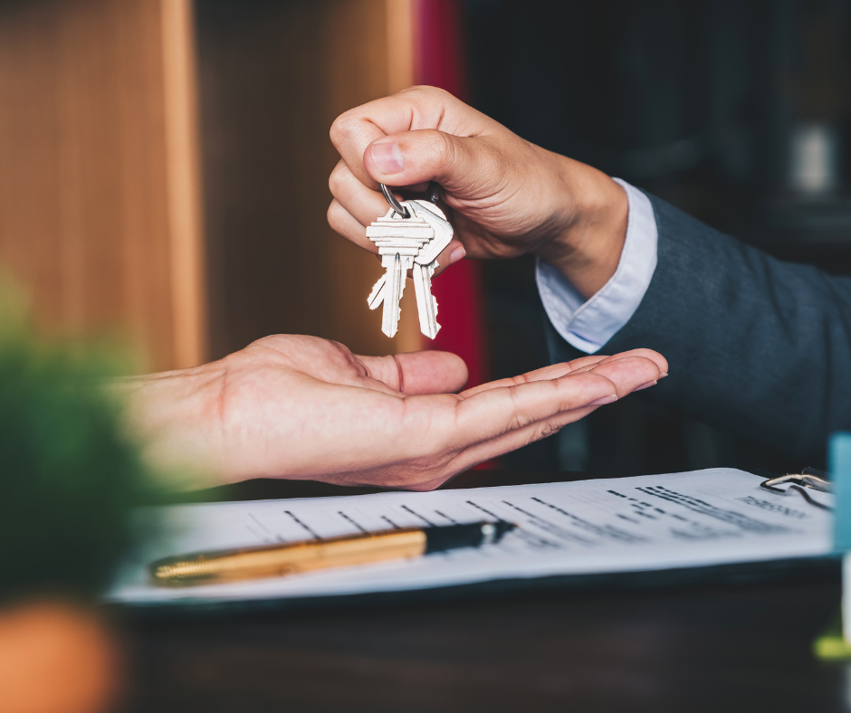 real-estate-agent-giving-house-keys-to-new-homeowner Closeup of real estate agent handing house keys to a new homeowner