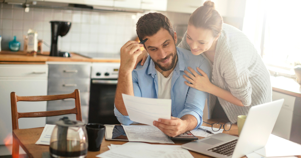 Young couple calculating home finances at their kitchen table