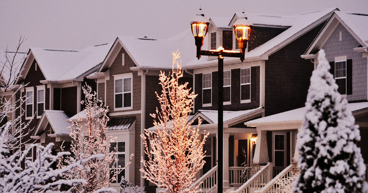 Snow-covered townhouses at dusk