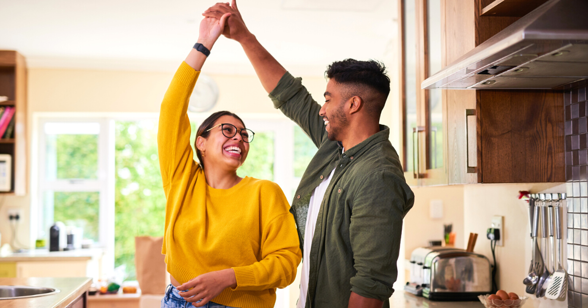 Shot of a young couple dancing together in their kitchen