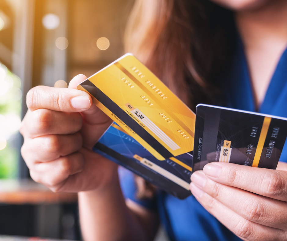 A woman holding three credit cards and choosing one
