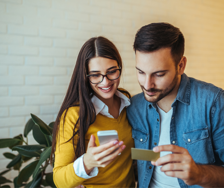 Young couple shopping online on their phone and using a credit card