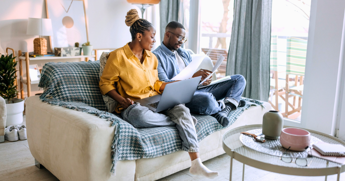 Young smiling couple working from home, going over paperwork