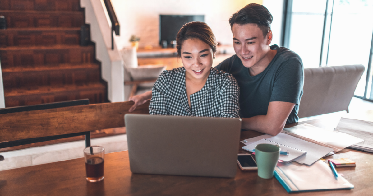 Smiling young couple planning budget at home