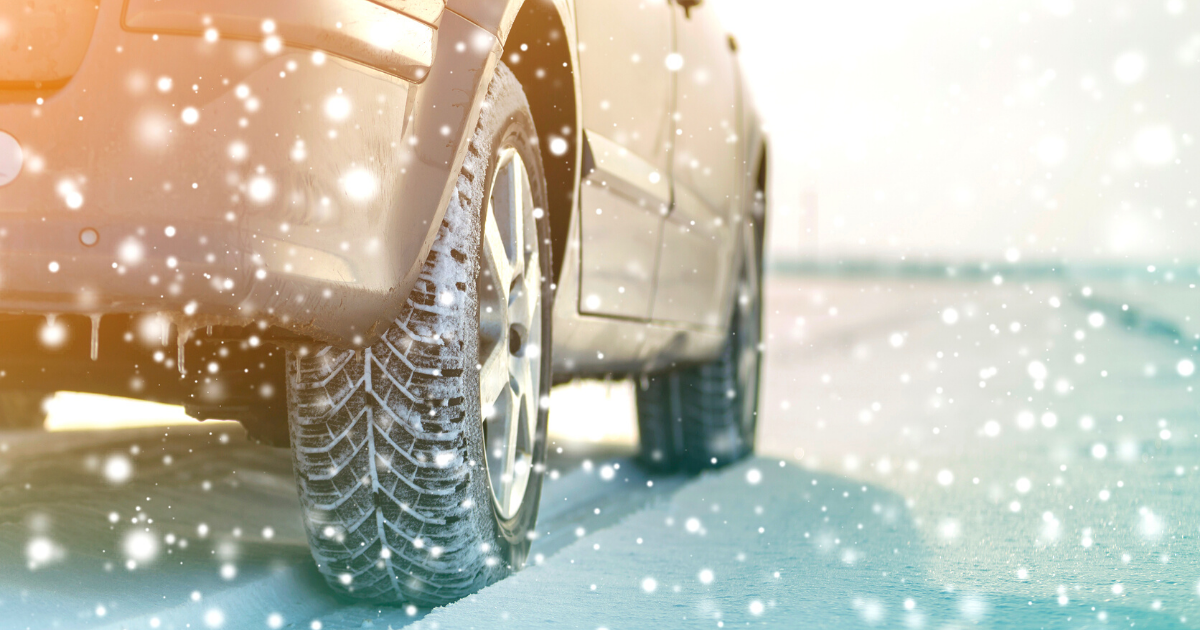 Close-up of car wheels rubber tires in deep winter snow. 