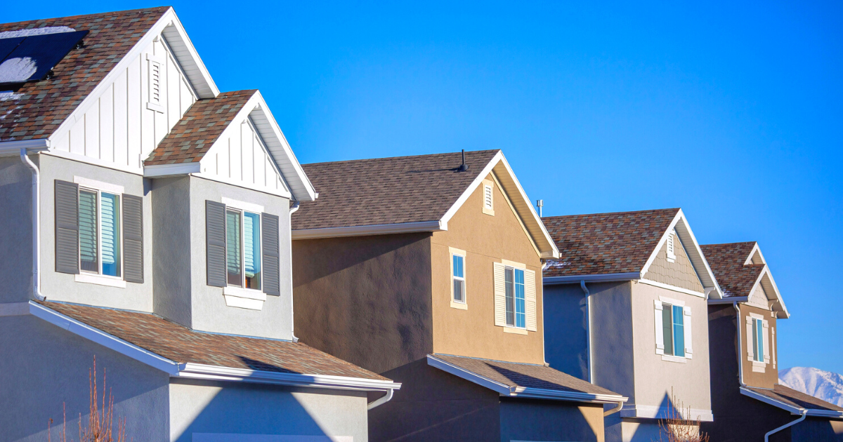 Four modern houses in a row under blue sky