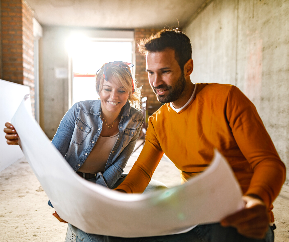 Young couple examining blueprints during home renovation process.