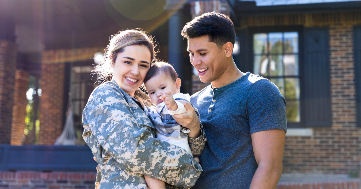 Happy female soldier outside in front of her house with her family