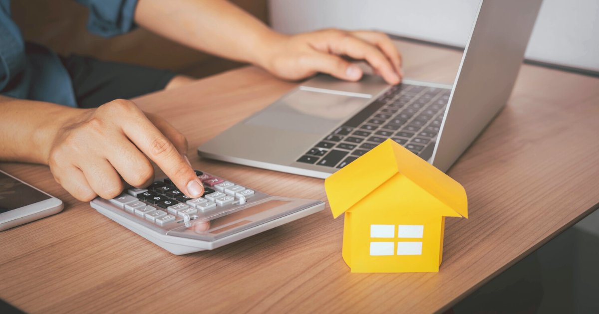 Man using a laptop and calculator to figure out his mortgage payments