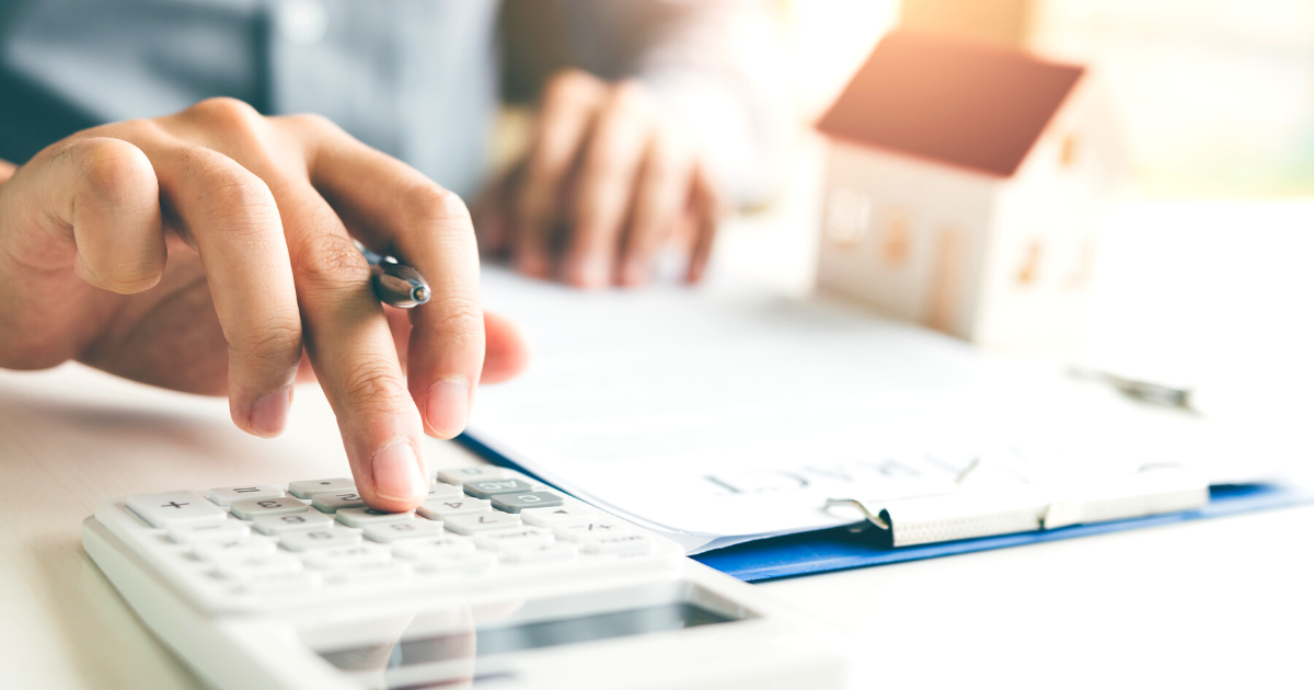 Home agent using a calculator to calculate the loan period each month for the customer