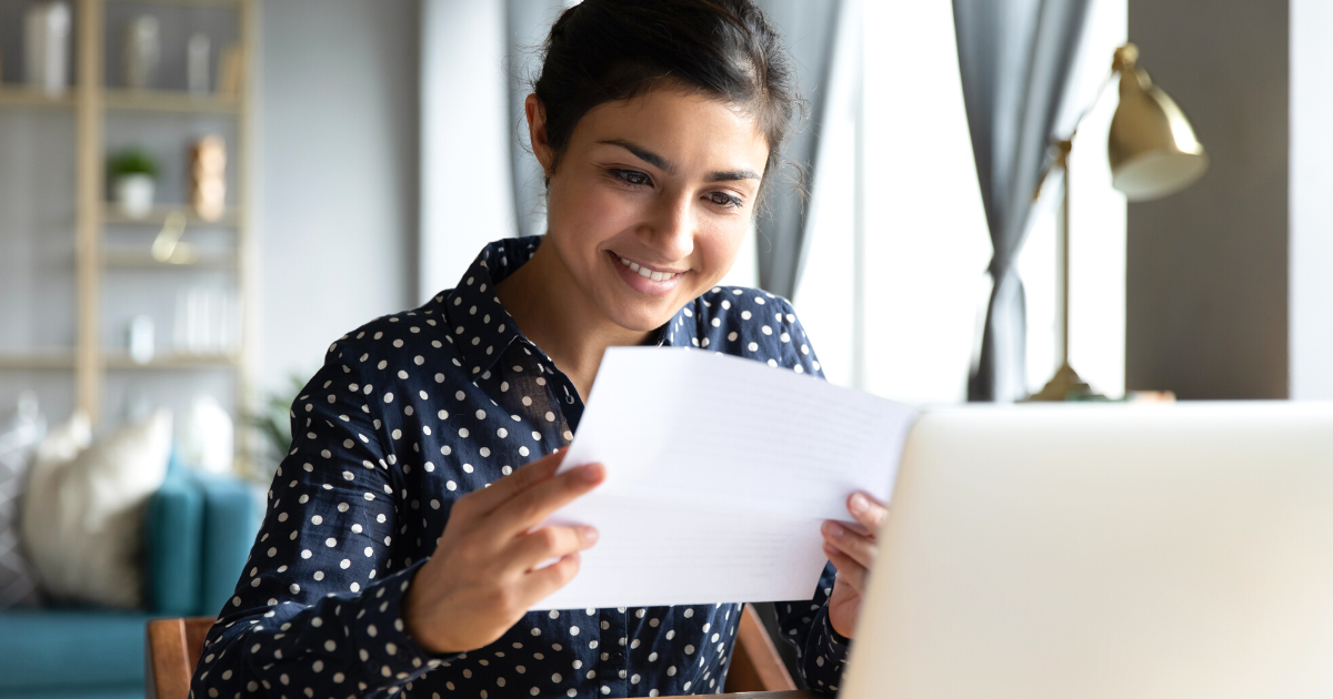 Smiling woman reading her mortgage pre-approval letter