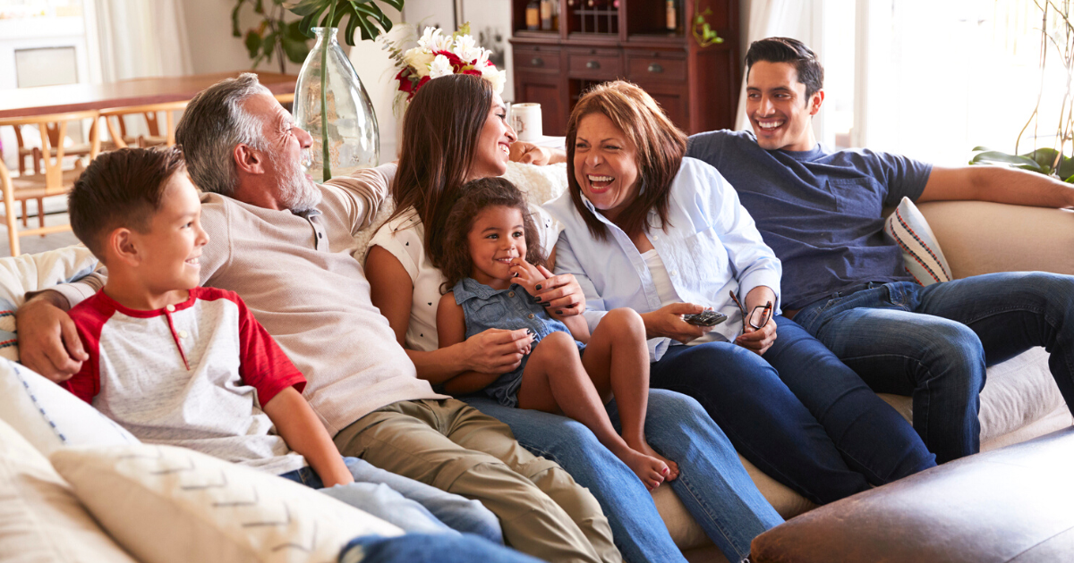 Three generation family sitting on the sofa watching TV