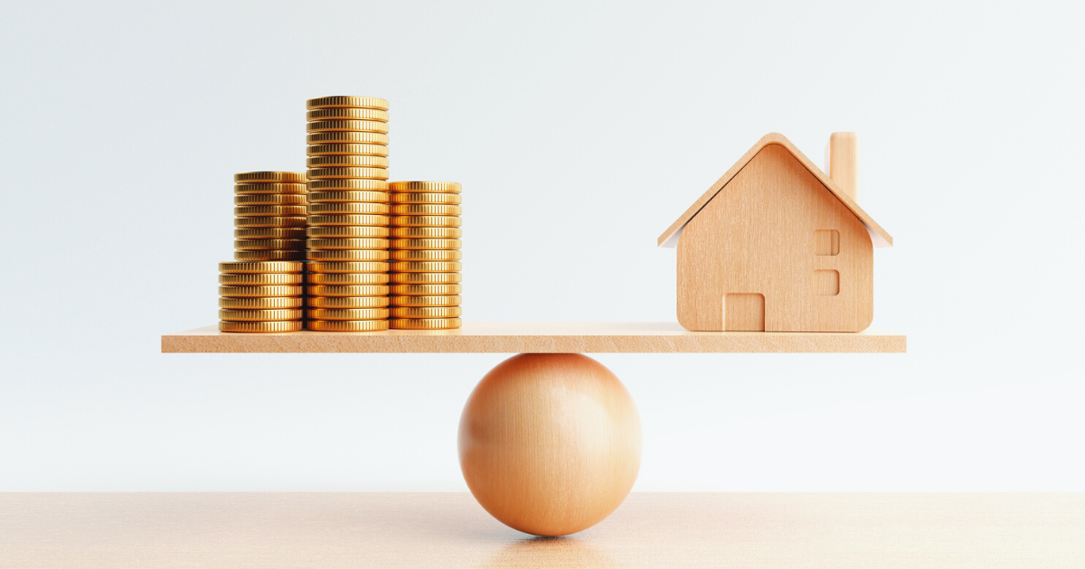 Wooden house and golden coin on balancing scale