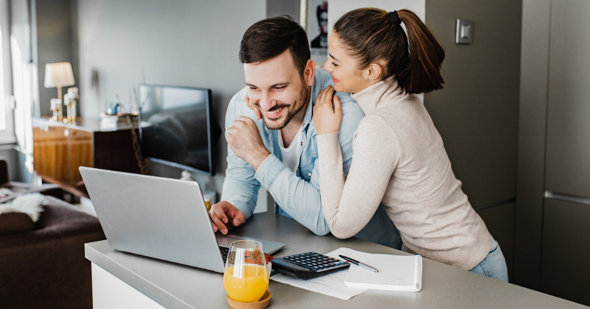 Young couple in their apartment applying for a mortgage on their computer