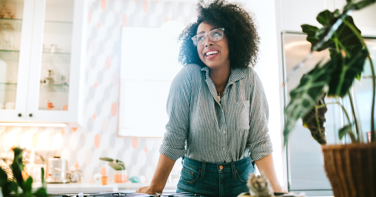 A happy young adult woman enjoys time at her new home, relaxing and basking in the enjoyment of her newly designed space.