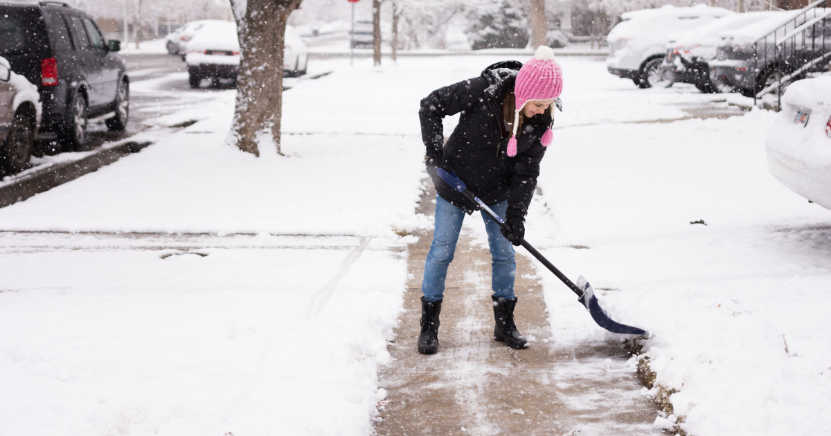 Woman in pink hat shoveling neighbors' snowy sidewalks