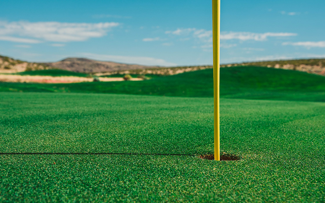 A flag inside a hole at a golf course