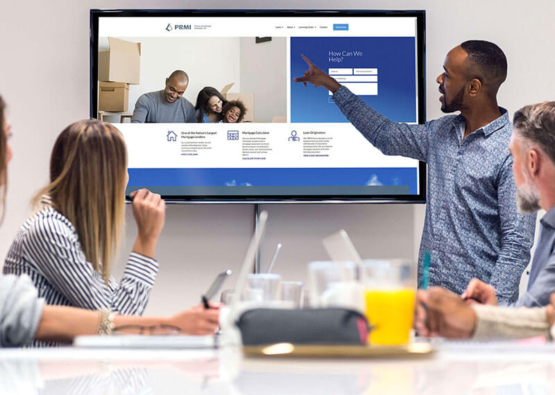 A team pointing at a tv screen during a meeting
