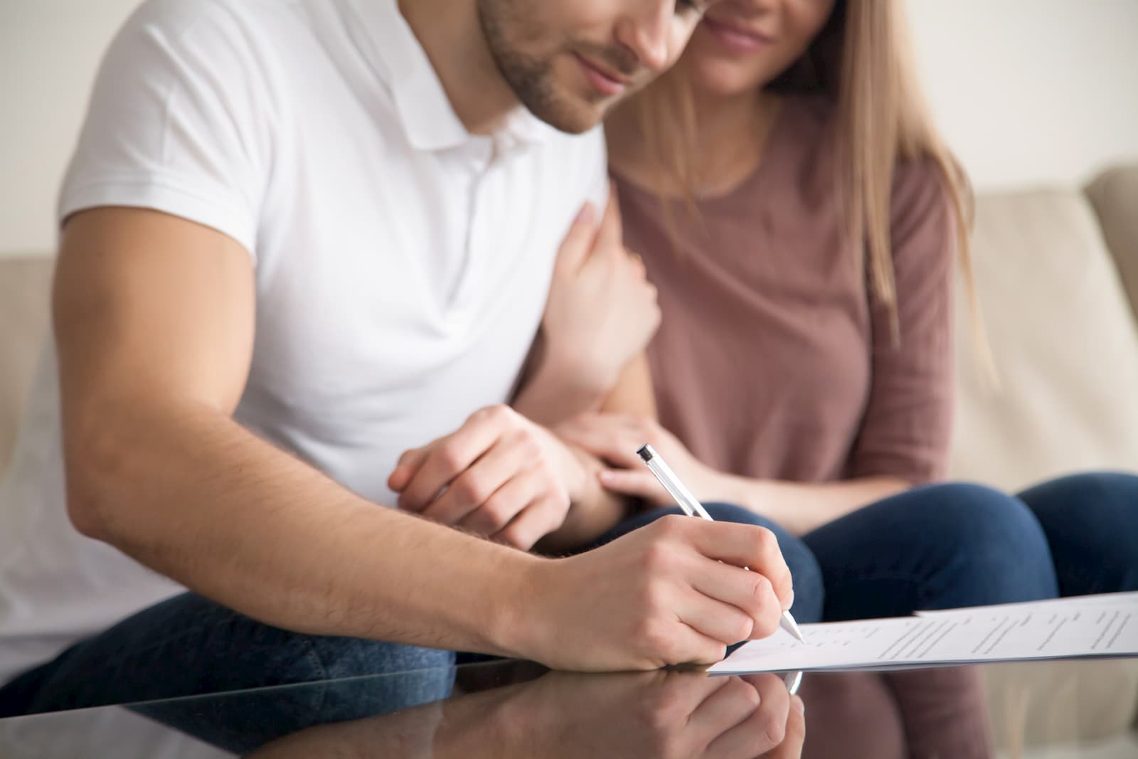 A couple sitting and signing paperwork