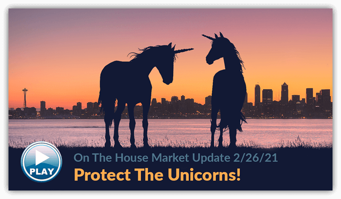 Two unicorns with the Seattle Washington skyline in the background at dusk
